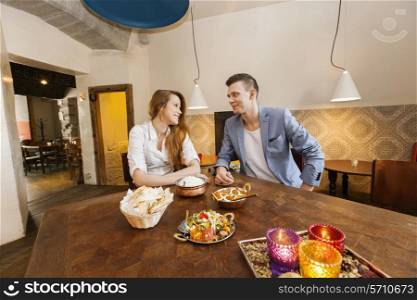 Young couple having food at restaurant