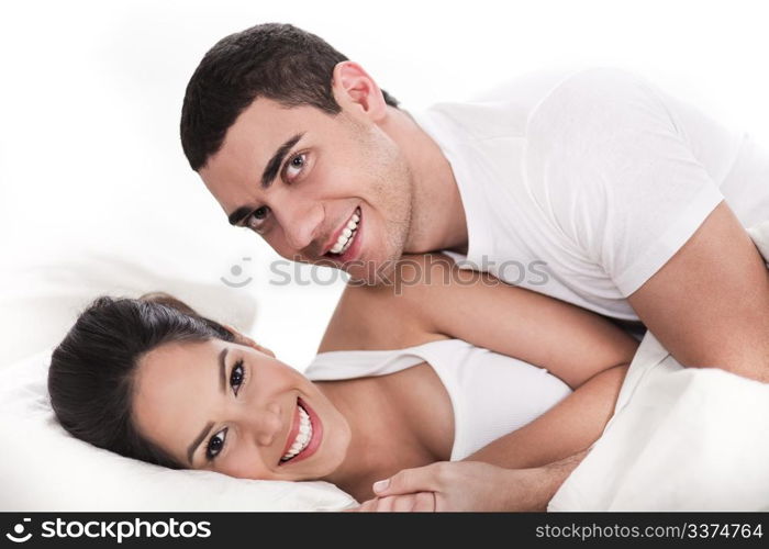 Young couple having fun in bed over white background