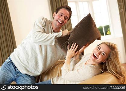 Young couple having fun laughing on sofa