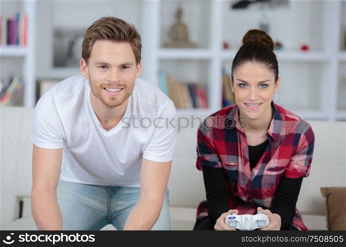 young couple having fun playing videogame at home