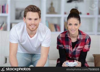 young couple having fun playing videogame at home