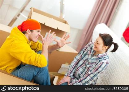 Young couple having fun while moving to new house