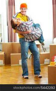 Young couple having fun while moving to new house