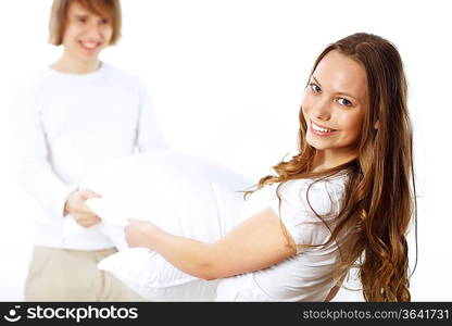 Young couple having fun with pillows at home