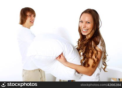 Young couple having fun with pillows at home