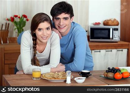 Young couple having pancakes for breakfast