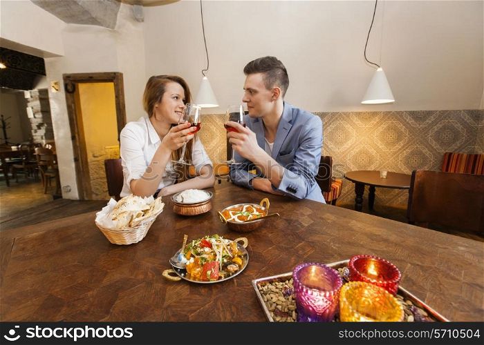 Young couple having wine at restaurant table