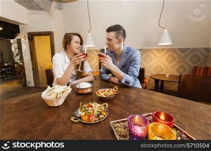 Young couple having wine at restaurant table
