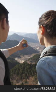 Young couple hiking and looking at the compass