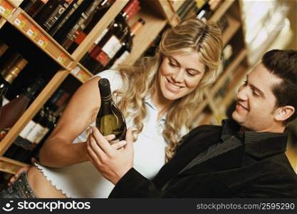 Young couple holding a wine bottle in a liquor store