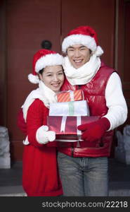 Young couple holding Christmas Gifts