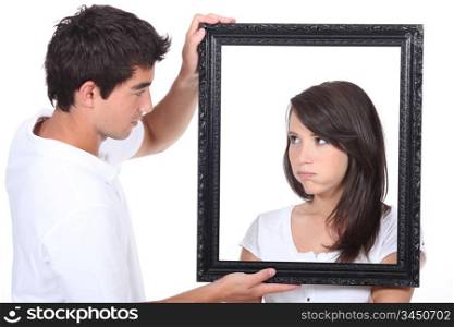 Young couple holding empty picture frame