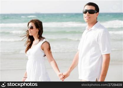 Young couple holding hands and walking by the beach,outdoor