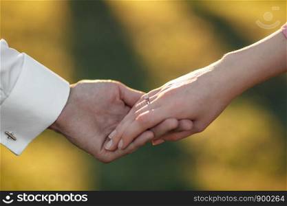 young couple holding hands on the arm ring. young couple holding hands on the arm ring. Close Up view