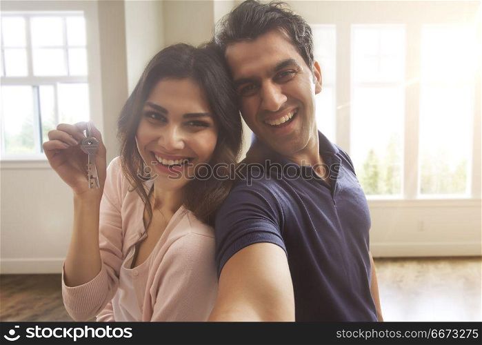 Young couple holding keys of new home