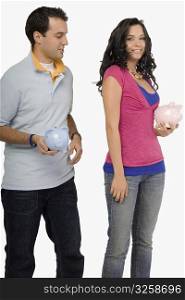 Young couple holding piggy banks