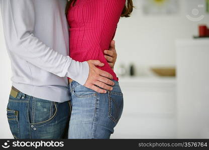 Young couple hugging at home