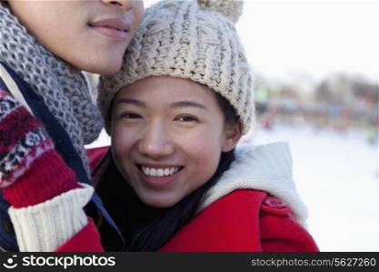 Young couple hugging at ice rink