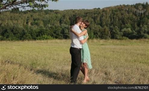 Young couple hugging on the yellow grass