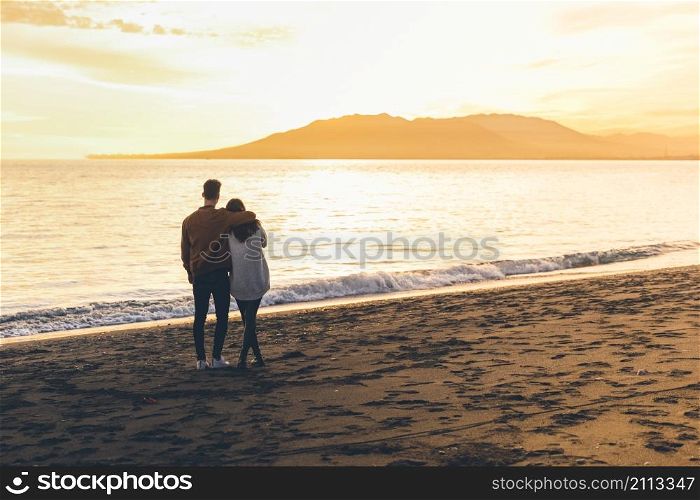 young couple hugging sea shore