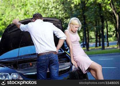 Young couple in a broken car