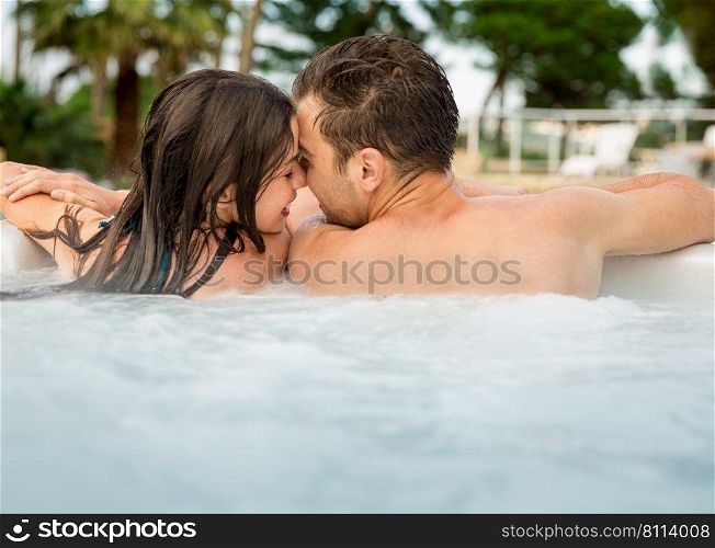 Young couple in a luxury hotel  inside a jacuzzi and kissing