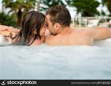 Young couple in a luxury hotel  inside a jacuzzi and kissing