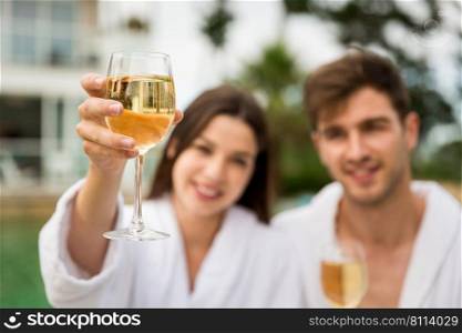 Young couple  in a luxury hotel tasting a glass of white wine