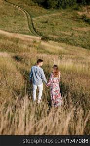 Young couple in are hugging love outdoor. Stunning sensual outdoor portrait of young stylish fashion couple posing in summer in field. Young couple in are hugging love outdoor. Stunning sensual outdoor portrait of young stylish fashion couple posing in summer in field.