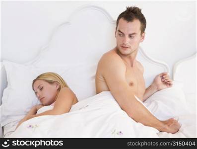 Young couple in bed having trouble sleeping