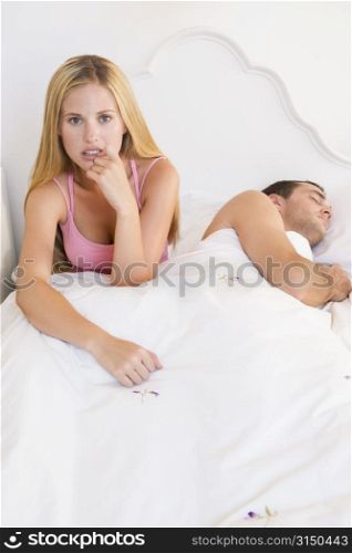 Young couple in bed having trouble sleeping