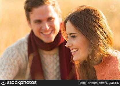 Young couple in field, smiling