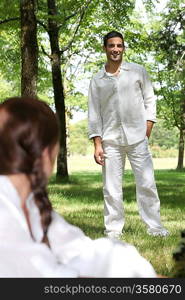 Young couple in forrest dressed in white clothing