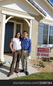 Young couple in front of new house
