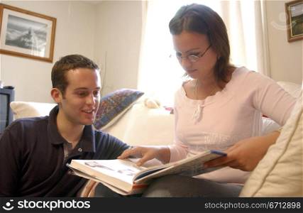 young couple in house looking at album