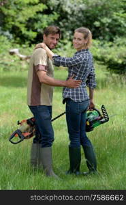 young couple in love cutting trees in forest