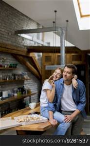 Young couple in love eating pizza for sneck in the rustic home