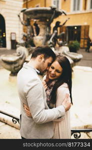 Young couple in love hugging near the fountains in Rome