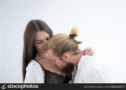 Young couple in love kissing and embracing each other on white background.