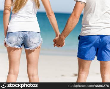 Young couple in love on the beach. Young couple in love on the beach holding hands