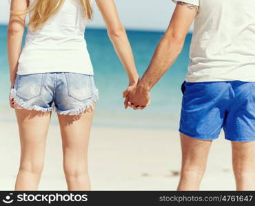 Young couple in love on the beach. Young couple in love on the beach holding hands