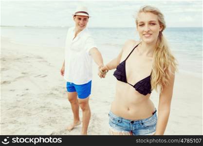 Young couple in love on the beach. Young couple in love on the beach holding hands