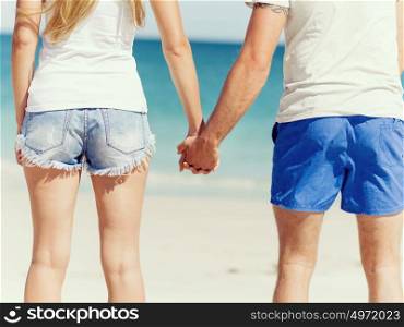 Young couple in love on the beach. Young couple in love on the beach holding hands
