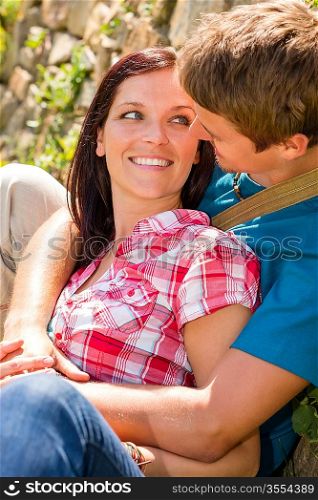 Young couple in love sitting outdoors looking at each other