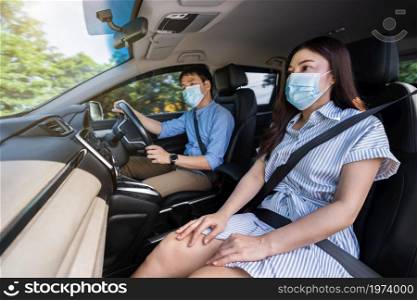young couple in medical mask while driving a car. for protect covid-19 (coronavirus) pandemic