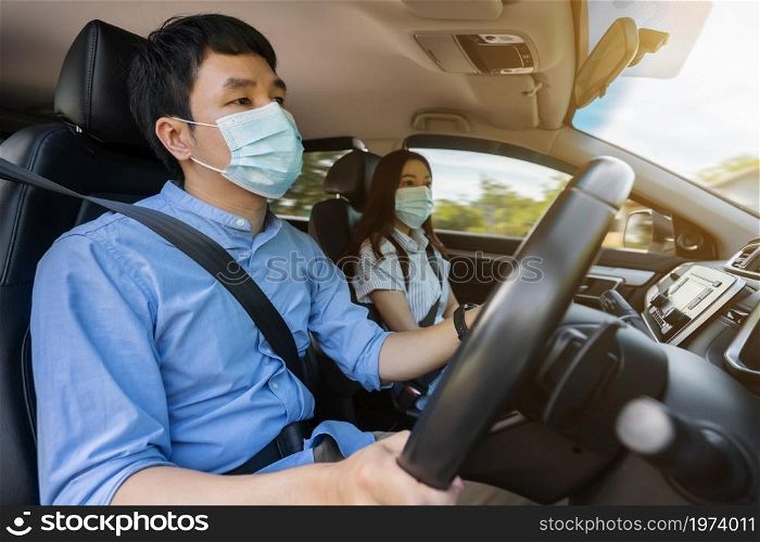 young couple in medical mask while driving a car. for protect covid-19 (coronavirus) pandemic