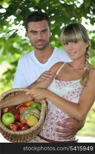 Young couple in park with fruit basket