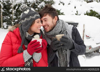 Young couple in snow with car