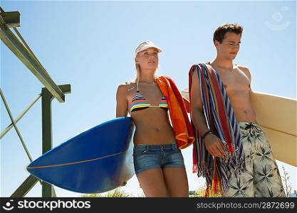 Young couple in swimwear with surfboards half length