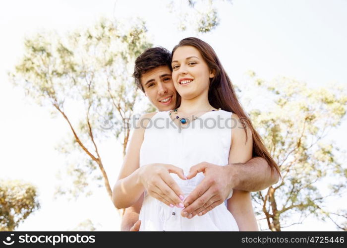 Young couple in the park. Young couple in the park and heart symbol